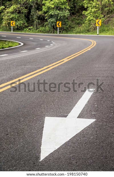 White\
forward arrow on the street at dangerous curve.\
