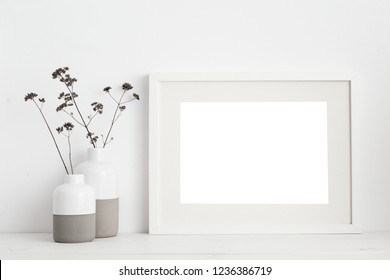 White Frame Mock Up And Dry Twigs In Vase On Book Shelf Or Desk. White Colors.

