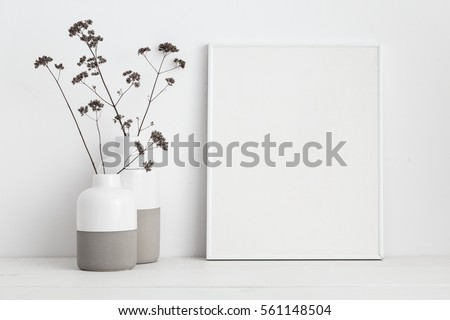  white frame mock up and dry twigs in vase on book shelf or desk. White colors.
