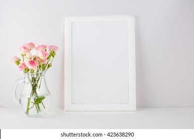 White frame mockup with pink roses. Frame mockup. White frame mockup. Poster product design styled mockup. Empty frame mockup. 