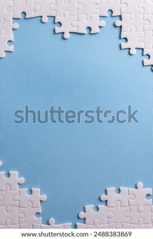 White frame from puzzle elements on light blue background. Business or educational concept. Vertical banner. Selective focus, copy space