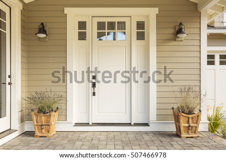 White front door with small square decorative windows and flower pots Сток-фото © 