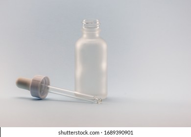 White Frosted Dropper Glass Bottle On A Light Blue Background. Organic, Natural Skincare And Makeup.