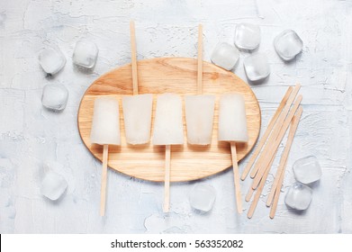 White frozen lollies and ice cubes on the white table