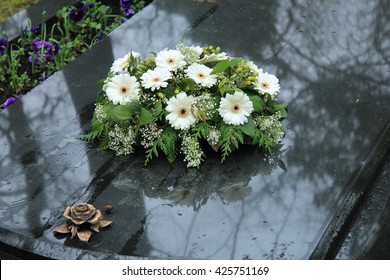 White Funeral Flowers On A Grey Marble Tomb