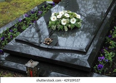 White Funeral Flowers On A Grey Marble Tomb