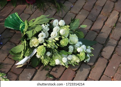 White Funeral Flowers On The Pavement Of A Cemetery