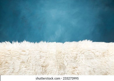 white fur carpet and blue painted wall , use for background