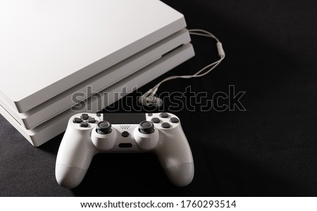White game console with control and handset on black background