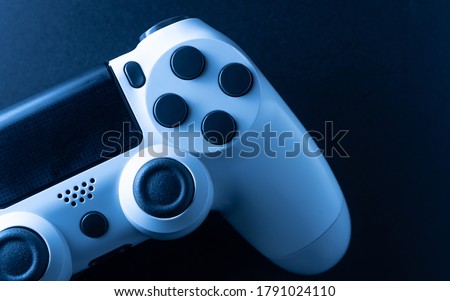 White game controller in black background and blue light