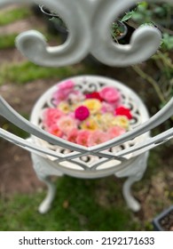 A White Garden Chair With Hart Shaped Backrest And Roses