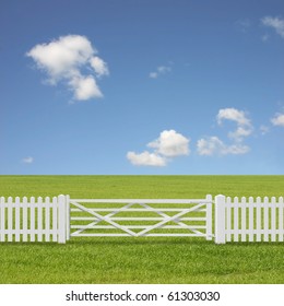 A White Gate And Fence With Grass Field