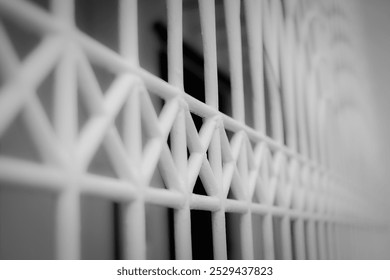 white gate with square and triangular gaps, black and white photo
