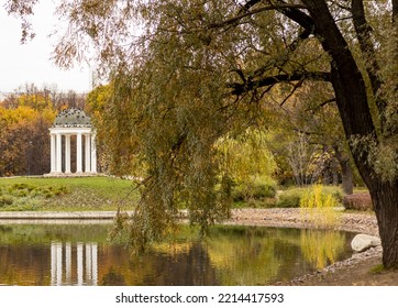 White Gazebo, Tree And Lake In Autumn Park