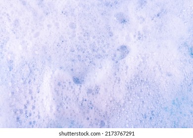 White gentle foam texture of modern cleansing cosmetic product for skin care as background extreme close view from above