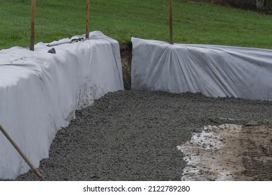 White Geotextile Layer Between Gray Raw Stones Gravel And Black Ground. Making Place For Parking And Beton Construction.