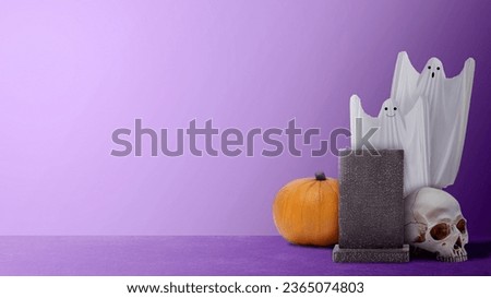 White ghost and pumpkin with a gravestone and human head skull on a colored background. Cute Halloween Wallpaper concept