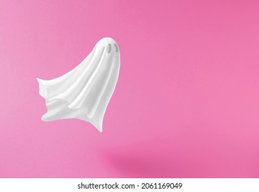 White Ghost Sheet Costume Against Pastel Pink Background. Minimal Halloween Scary Concept.