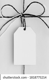 White Gift Tag Mockup On A White Christmas Gift.