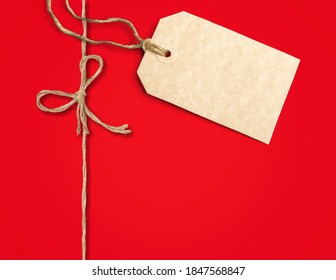 White Gift Tag Mockup On A Red Christmas Gift.