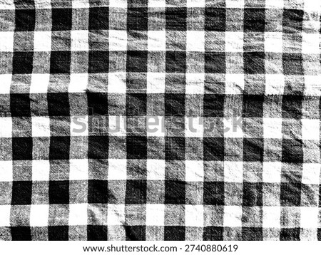 
​Black and white gingham fabric texture background. Classic checkered pattern on cotton textile material with natural folds and wrinkles. Minimalist buffalo plaid design for fashion or decor.