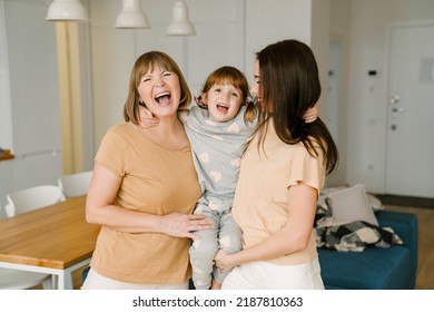 White Girl Laughing While Playing With Her Mother And Granddaughter At Home