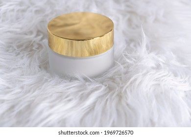 A White Glass Jar For Moisturizing Cream With A Gold Lid On A Palm Leaf Shadow Background. Mockup For Branding Product Packaging.