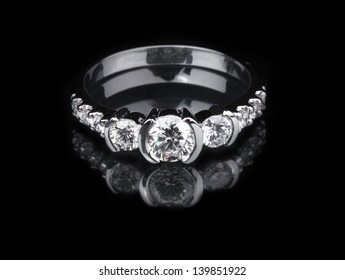Weißer goldener Diamantring auf schwarzem Hintergrund