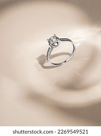 White gold ring and diamond beige background and shadows  Still life   creative photo