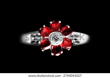 White gold ring with ruby crystals flower isolated on black background
