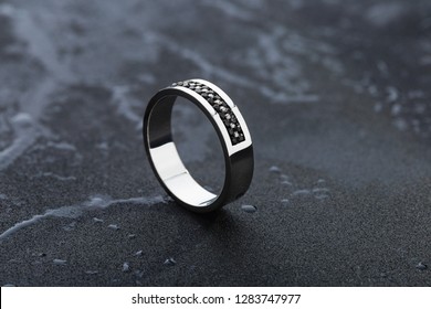 White Gold Wedding Ring With Black Gemstones On Black Background. Fashion Mens Jewellery