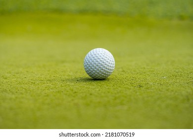 White Golf Ball On Green Fake Grass.