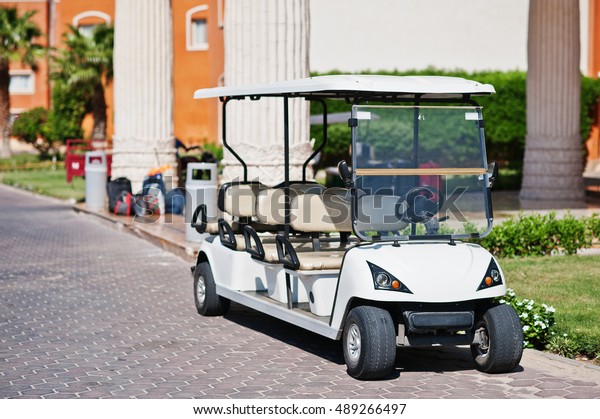White golf car with\
back seat on resort. 