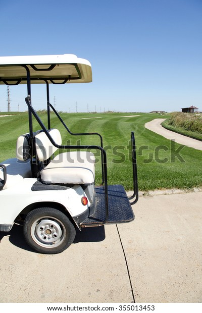 White golf carts at\
the green golf course