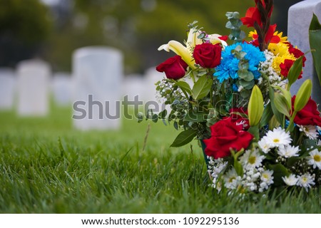 white grave markers and flowers at a national cemetary