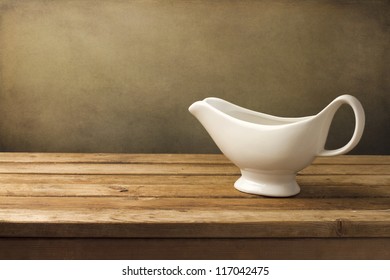 White Gravy Boat On Wooden Table Over Grunge Background