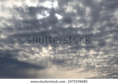 white gray textured clouds precede darker storm clouds