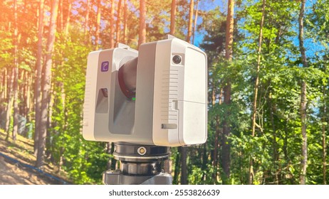 A white and grey camera is on a tripod in a forest. The camera is pointed towards the sky - Powered by Shutterstock