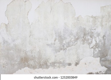 White  grey old  wall with shabby damaged plaster Cement and brick background of an vintage dirty exfoliating plaster  Textured background peeling of colour wallpaper cement