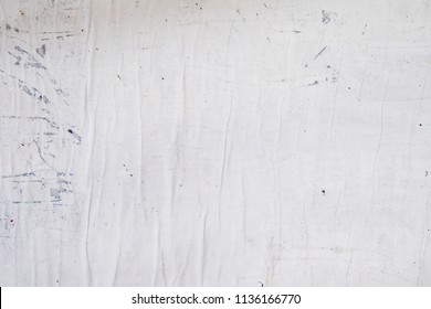 white grey street poster glued to a wall with wheat paste, empty rippled wrinkled creased paper texture - Shutterstock ID 1136166770