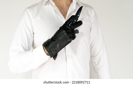 White Guy With Shirt And Black Glove Holding Knife Hand On White Background. Men Hold Knife With Leaher Glove. Killer, Psycho, Mafia Or Gangster Isolated. 