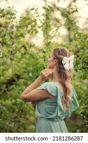 white hairpin bow on women's hair. back view in blooming garden - Shutterstock ID 2181286287
