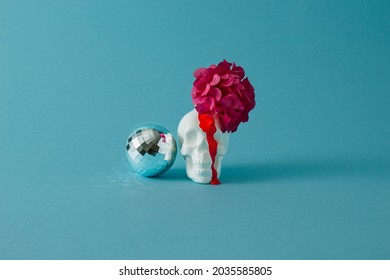 White Halloween Skull With The Bloomed Purple Flower And Disco Ball And Red Blood Dripping Down Its Face: Minimal Concept.