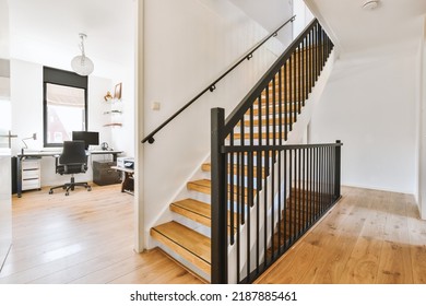 White Hallway With Wooden Stairway Leading To Second Floor Of Modern Luxury Apartment With Minimalist Interior Design