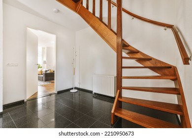 White Hallway With Wooden Stairway Leading To Second Floor Of Modern Luxury Apartment With Minimalist Interior Design