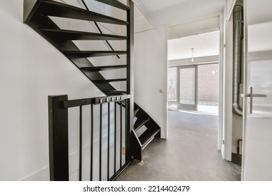 White Hallway With Wooden Stairway Leading To Second Floor Of Modern Luxury Apartment With Minimalist Interior Design