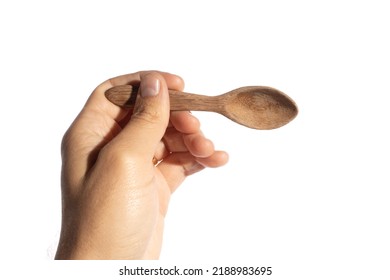 White Hand Holding A Little Wood Spoon. The Subject Is Isolated In Perfect Pure White Background.