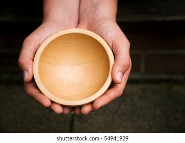 White Hands Holding A Wooden Begging Bowl