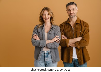 White happy couple wearing shirts smiling and looking at camera isolated over beige background - Powered by Shutterstock