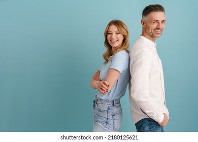 White Happy Man And Woman Smiling While Standing Back To Back Isolated Over Blue Background